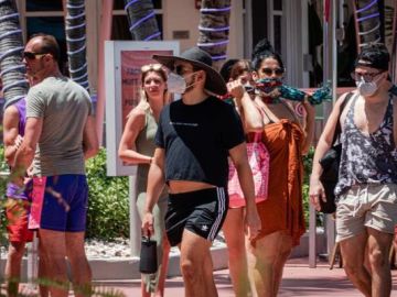 Un grupo de personas pasea con mascarilla por Miami