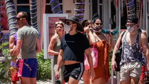 Un grupo de personas pasea con mascarilla por Miami Un grupo de personas pasea con mascarilla por Miami