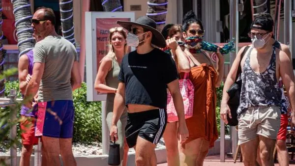 Un grupo de personas pasea con mascarilla por Miami