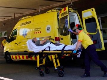 Técnicos sanitarios transportan a un enfermo en la entrada de urgencias del hospital Arnau de Vilanova de Lleida