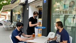 Imagen de dos j&oacute;venes con mascarilla en una terraza de Lleida