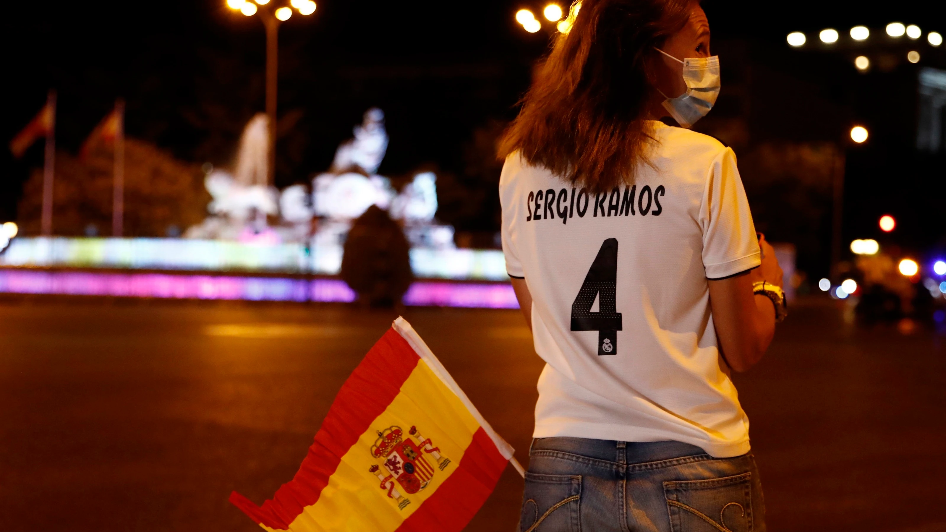 Una aficionada del Real Madrid ante una Cibeles sin aficionados