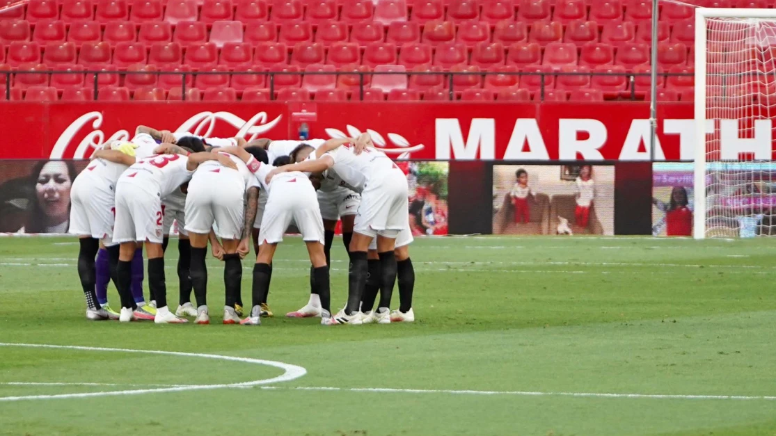 Los jugadores del Sevilla hace una pi&ntilde;a antes de un partido