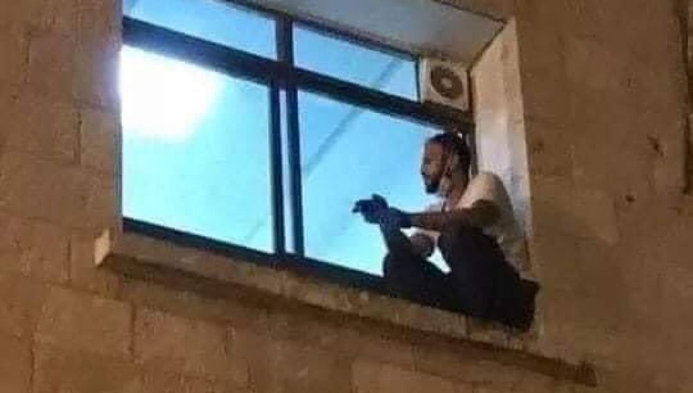 Un joven trepa por la fachada de un hospital en Cisjordania para despedirse de su madre fallecida por coronavirus