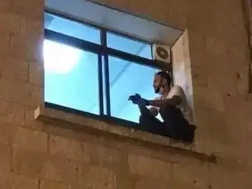 Un joven trepa por la fachada de un hospital en Cisjordania para despedirse de su madre fallecida por coronavirus Un joven trepa por la fachada de un hospital en Cisjordania para despedirse de su madre fallecida por coronavirus