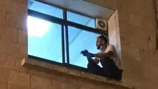 Un joven trepa por la fachada de un hospital en Cisjordania para despedirse de su madre fallecida por coronavirus Un joven trepa por la fachada de un hospital en Cisjordania para despedirse de su madre fallecida por coronavirus