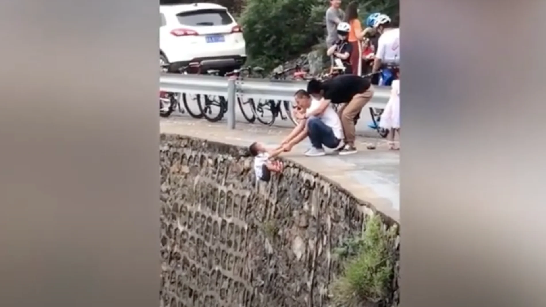 El padre colocando al niño en el acantilado El padre colocando al niño en el acantilado