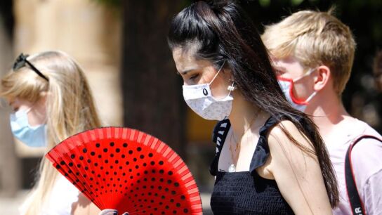 Varias mujeres caminan con mascarilla