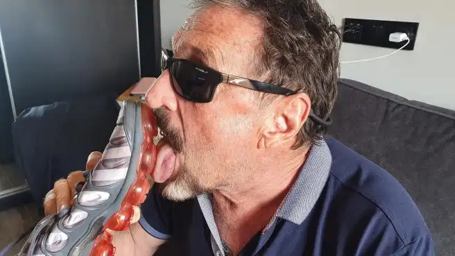 John McAfee desafia al coronavirus lamiendo la suela de una zapatilla coronavirus
