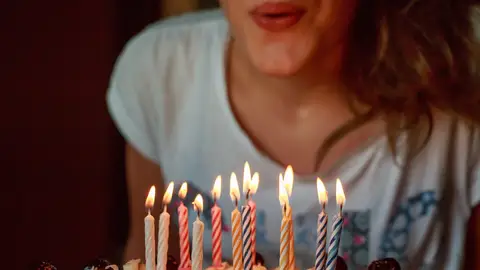 Imagen de archivo de una joven soplando las velas de una tarta Sanciones coronavirus