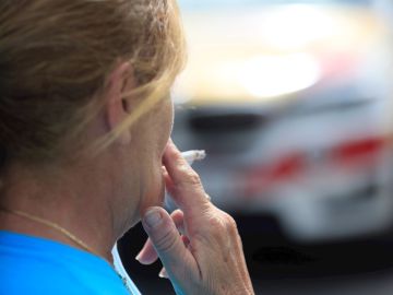 Una mujer se fuma un cigarrillo