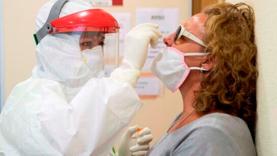 Una enfermera del 061 hace una prueba PCR a una mujer