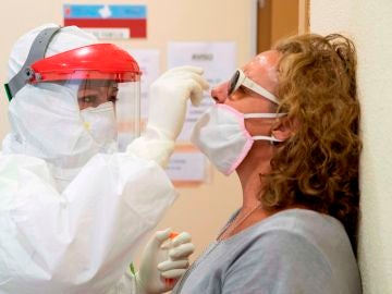 Una enfermera del 061 hace una prueba PCR a una mujer