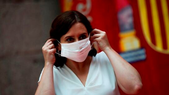 Imagen de Ayuso coloc&aacute;ndose una mascarilla