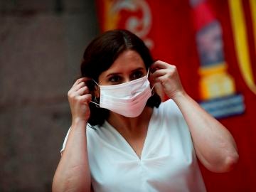 Imagen de Ayuso colocándose una mascarilla