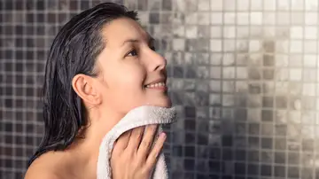 Mujer secándose después de la ducha con una toalla
