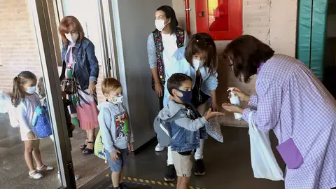 Varios niños entrando al colegio con mascarilla Varios niños entrando al colegio con mascarilla