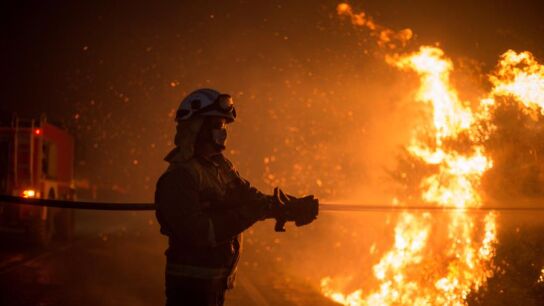  Varios bomberos realizan labores de extinci&oacute;n hoy domingo en el incendio forestal de Cualedro, Ourense
