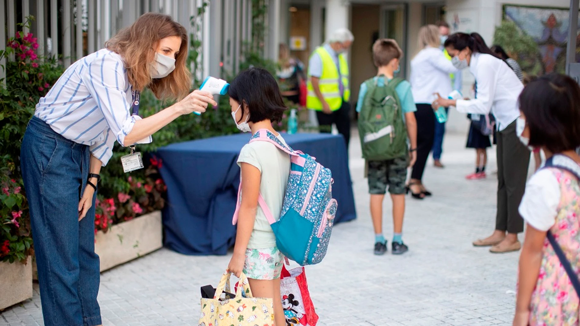 Una trabajadora toma la temperatura a una niña en un colegio de Barcelona Una trabajadora toma la temperatura a una niña en un colegio de Barcelona