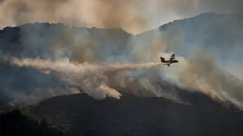 Una avioneta lanza agua sobre un incendio Una avioneta lanza agua sobre un incendio