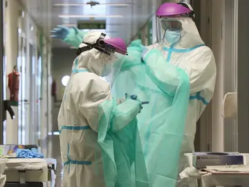 Sanitarios colocándose el traje EPI Sanitarios colocándose el traje EPI