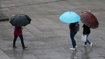 Escolares se protegen de la lluvia con paraguas este viernes en Bilbao
