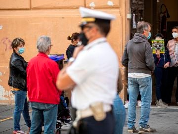 Italianos con mascarillas a la salida de un colegio en Roma