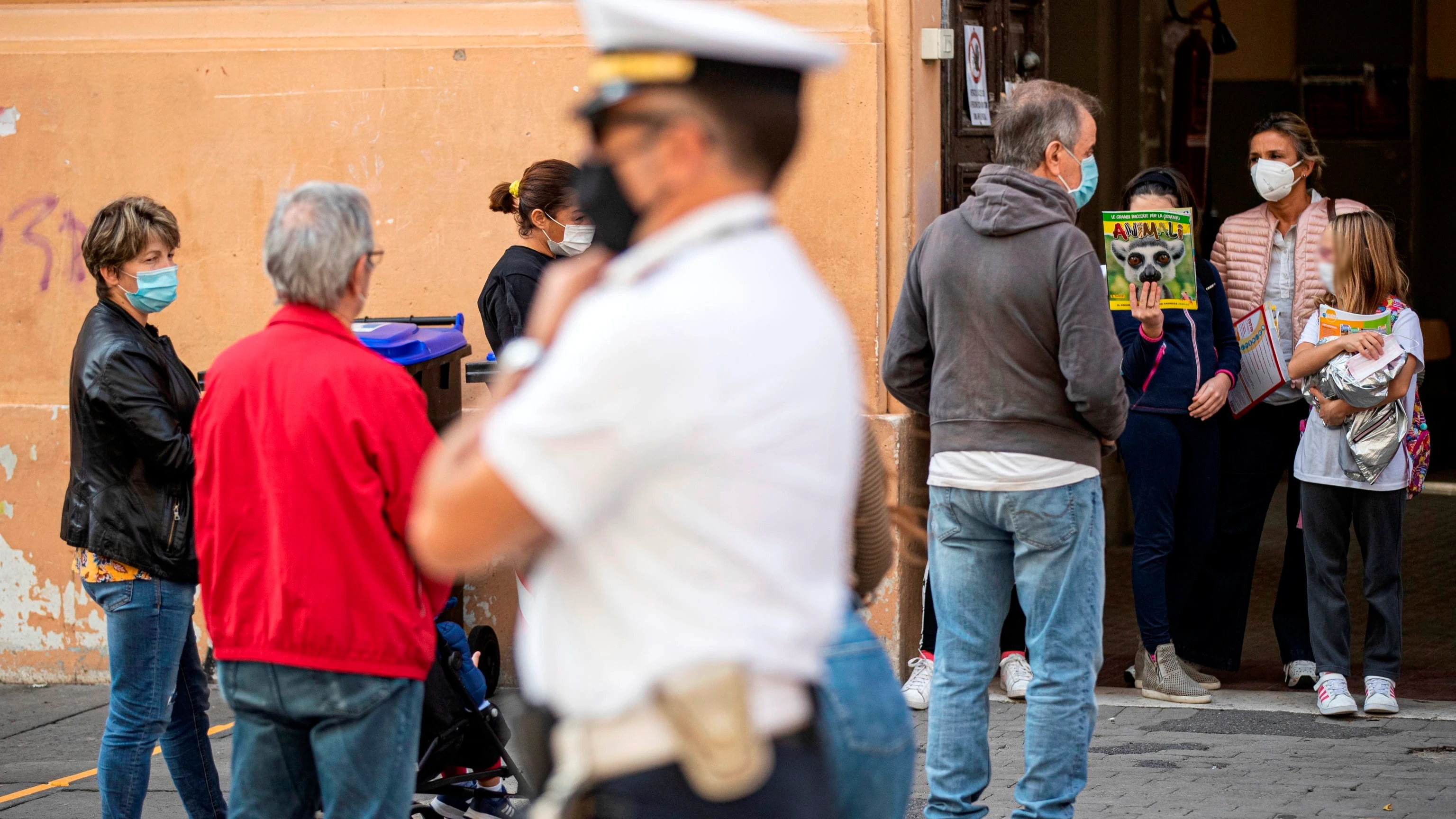 Italianos con mascarillas a la salida de un colegio en Roma Italianos con mascarillas a la salida de un colegio en Roma