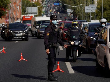 Un agente controla la movilidad en la salida de Madrid (Archivo)