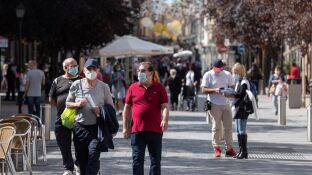 Personas con mascarilla pasean en Alcal&aacute; de Henares