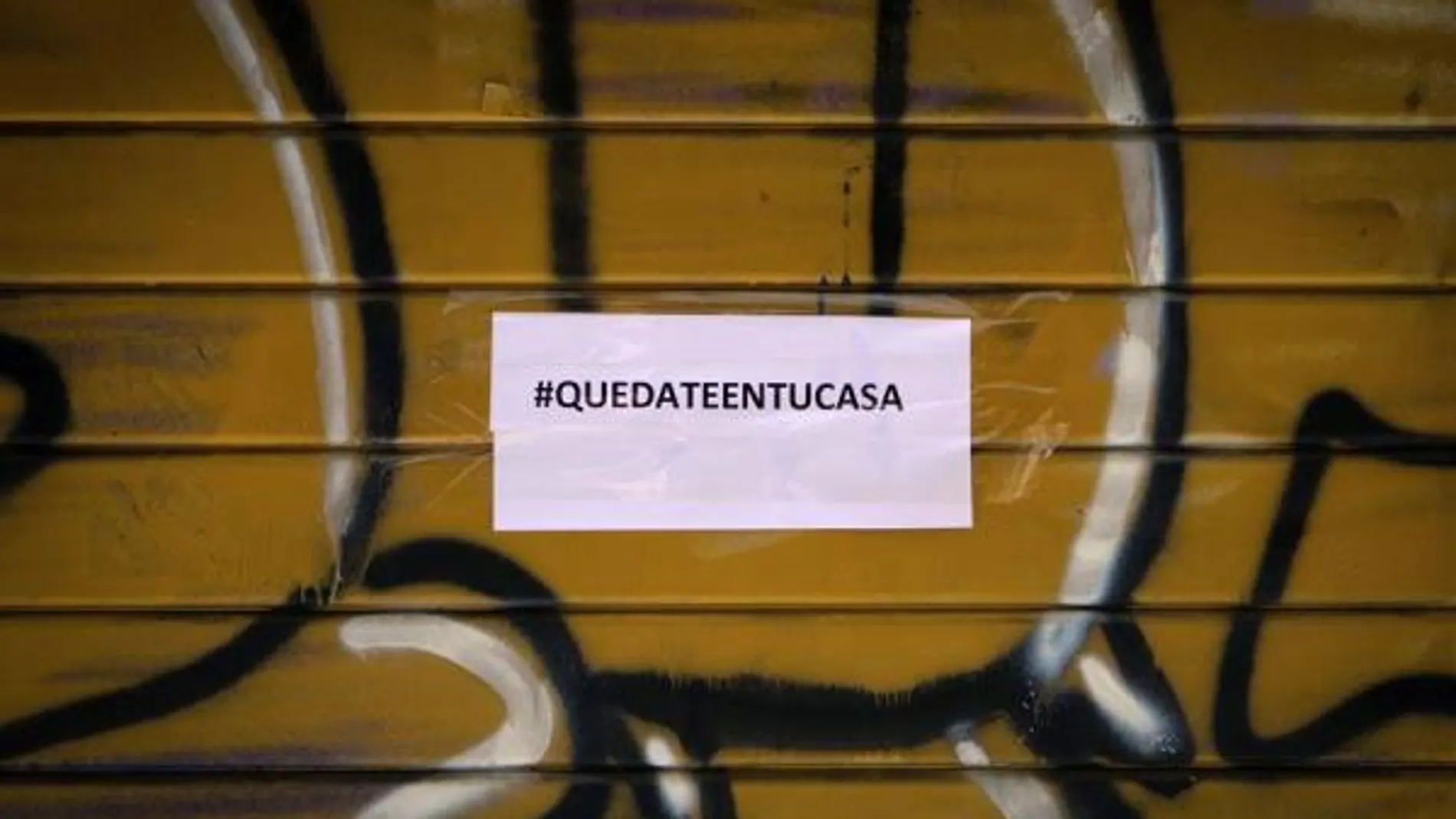 Imagen de un comercio cerrado con un cartel de Quedateentucasa Imagen de un comercio cerrado con un cartel de Quedateentucasa