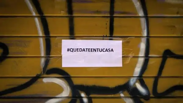 Imagen de un comercio cerrado con un cartel de Quedateentucasa Imagen de un comercio cerrado con un cartel de Quedateentucasa