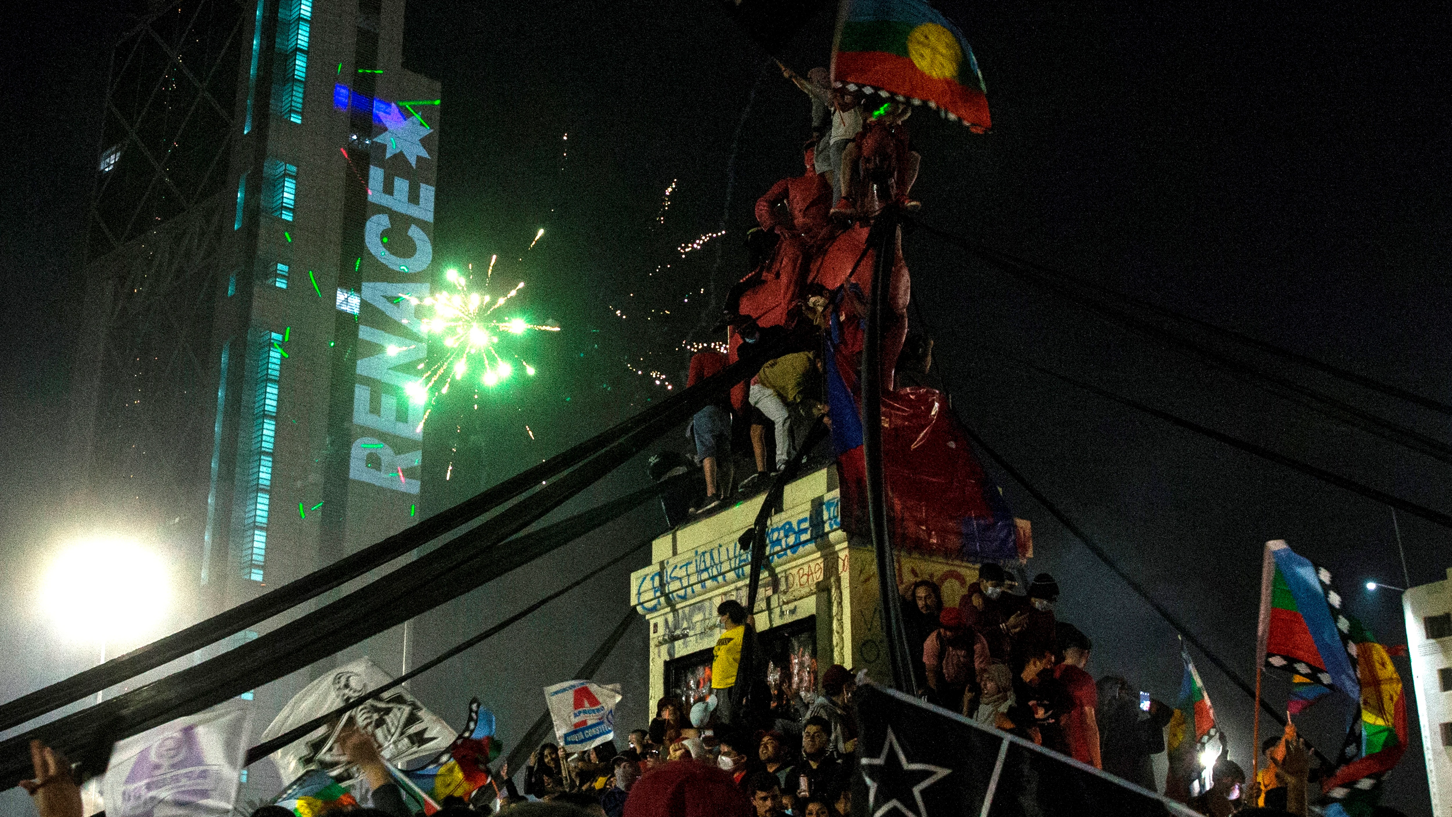 Decenas de personas celebran luego de conocer los resultados parciales del plebiscito constitucional, que apuntan al triunfo por una nueva Carta Magna hoy, en Santiago (Chile).