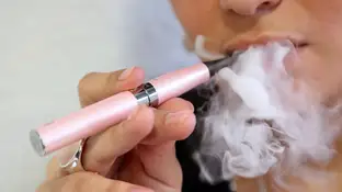 Una persona fumando con un cigarrillo electrónico Una persona fumando con un cigarrillo electrónico