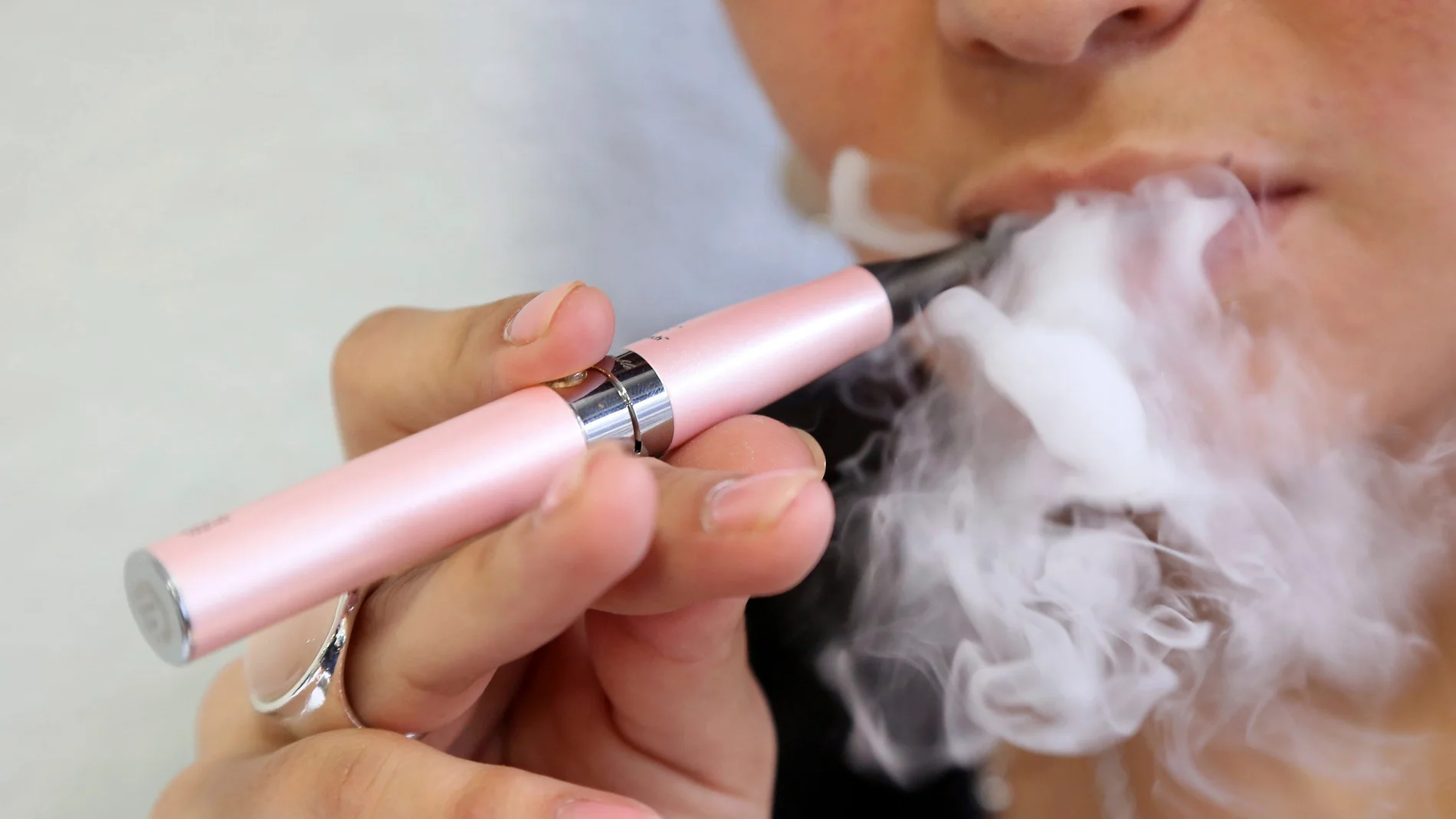 Una persona fumando con un cigarrillo electrónico Una persona fumando con un cigarrillo electrónico