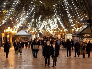 Gente paseando por el paseo Born en Barcelona con el encendido navideño