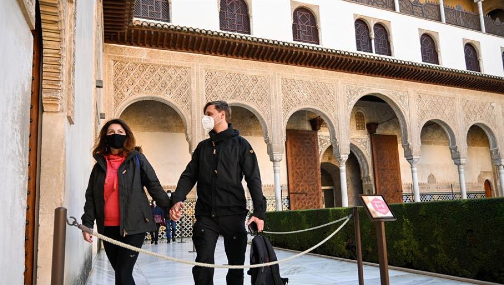 Dos turistas caminan por el interior de la Alhambra.