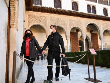 Dos turistas caminan por el interior de la Alhambra.