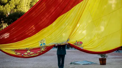 Un militar sujeta la bandera española Un militar sujeta la bandera española