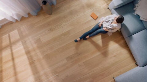 Sentada en suelo de parquet
