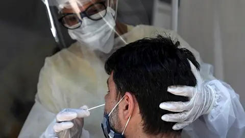 Un sanitario realiza un test covid a una persona Un sanitario realiza un test covid a una persona