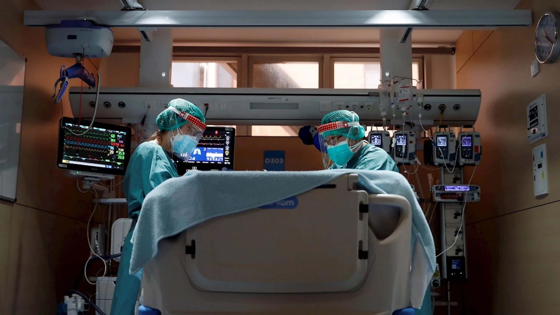 Dos médicos atienden a un paciente con coronavirus en un hospital. Dos médicos atienden a un paciente con coronavirus en un hospital.