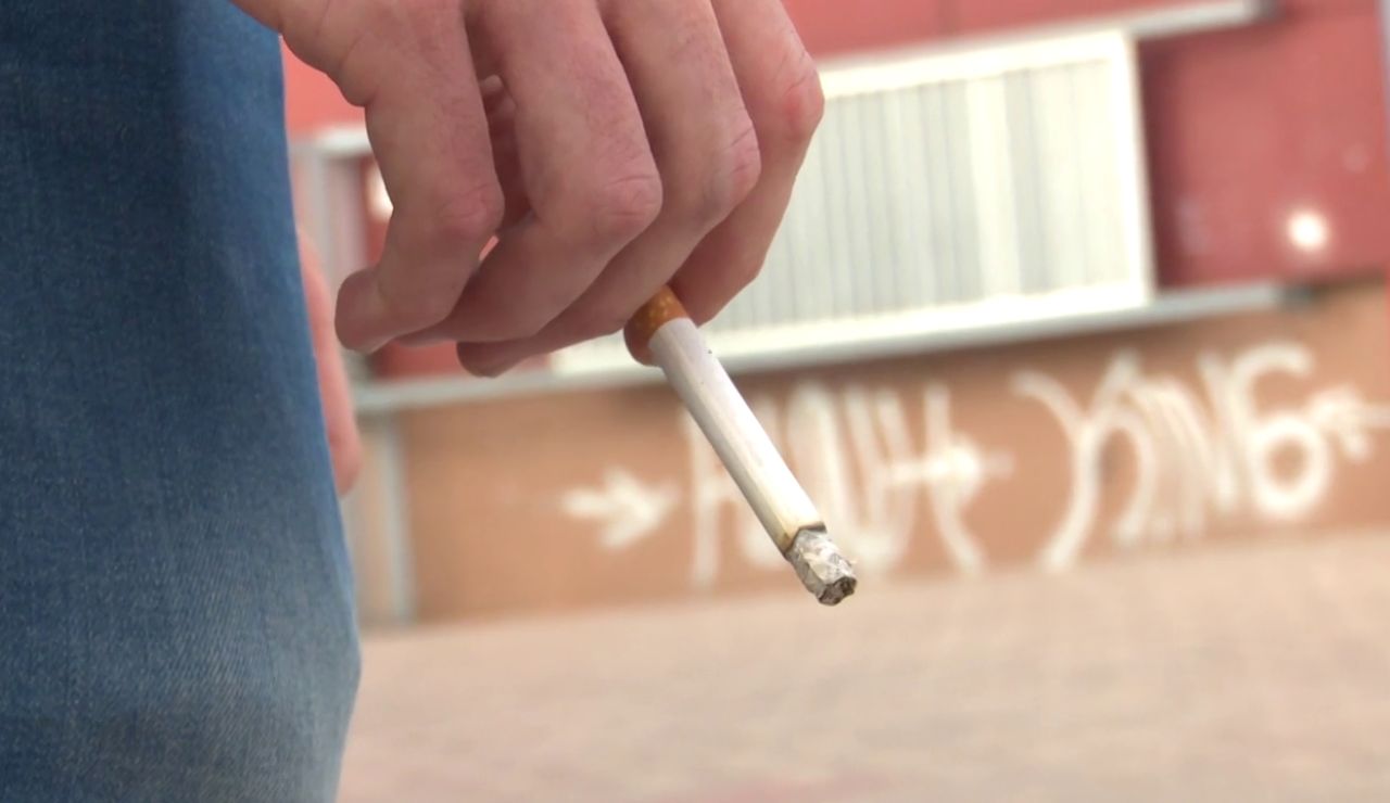 Una persona con un cigarrillo en la mano