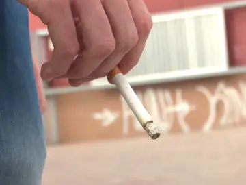 Una persona con un cigarrillo en la mano Una persona con un cigarrillo en la mano
