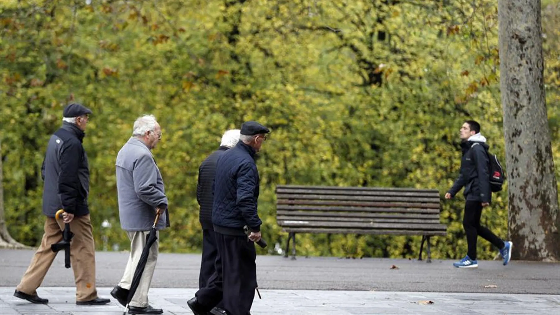 Jubilados y pensionistas pasean en un parque de Bilbao.