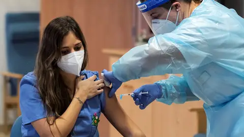 Imagen de una sanitaria mientras le inyectan la vacuna Imagen de una sanitaria mientras le inyectan la vacuna