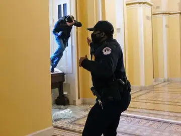 Un policía se defiende del asalto al Capitolio de Estados Unidos Un policía se defiende del asalto al Capitolio de Estados Unidos