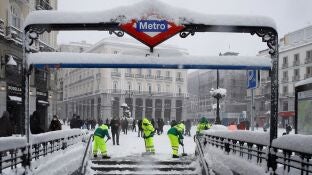 Operarios trabajan para retirar nieve y mejorar la circulaci&oacute;n en la Puerta del Sol en Madrid