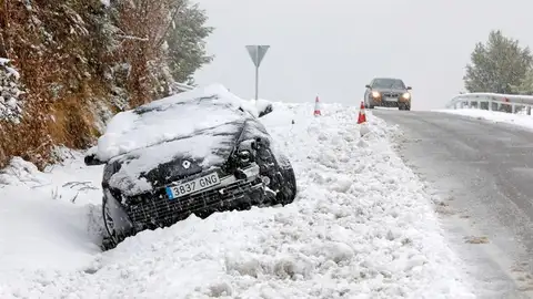 Imagen de un coche atascado en la nieve La acumulación de nieve ha provocado que este coche se salga de la carretera en Cataluña