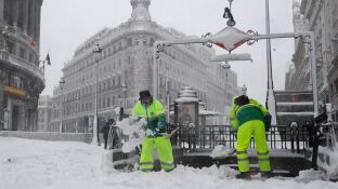 Operarios quitan la nieve en las cercan&iacute;as a la Puerta del Sol de Madrid